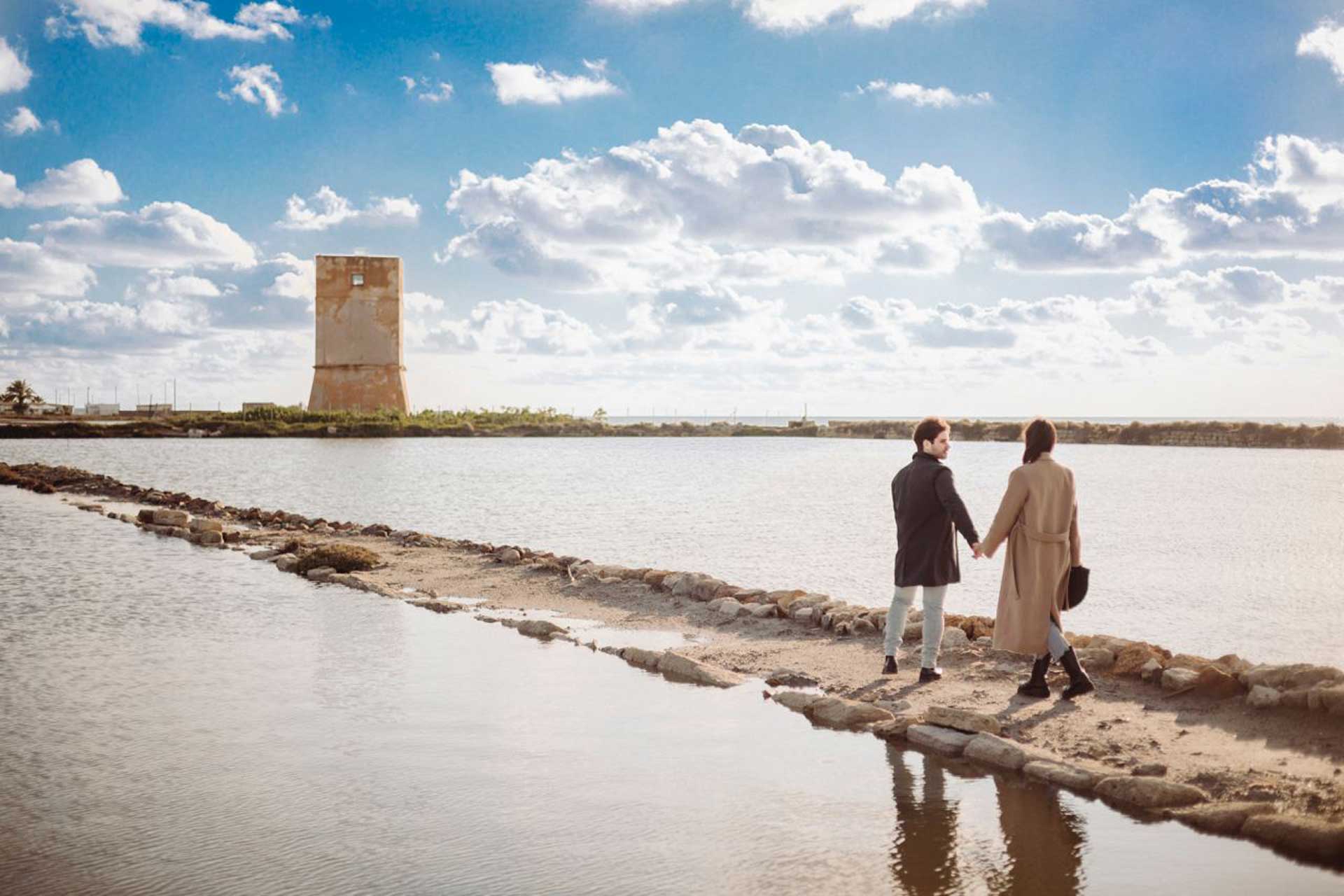 Servizio video Pre-Wedding alle Saline di Nubia a Trapani, coppia elegante al tramonto tra dune di sale