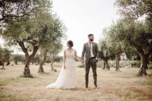 Bride and groom celebrating their wedding in an exclusive villa in Trapani, surrounded by olive trees and local dishes, captured in a refined wedding film.*tipici, immortalati in un wedding film raffinato.